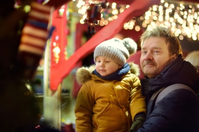 Vater und Sohn stehen glücklich im Lichterglanz bei Ibbs Christmastime