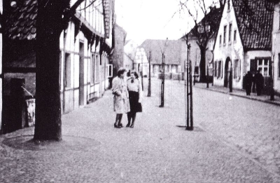 Schwarz-weißes Foto von früher. 2 Frauen stehen in der Bachstraße mit links und rechts Häuserreihen