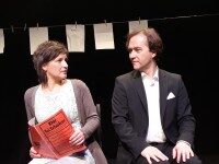 Theater Eine Frau und ein Mann sitzen auf einer Bühne und schauen sich an.
