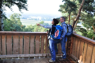 Mann und Frau stehen auf der Aussichtsplattform der Almhütte der Dörenther Klippen