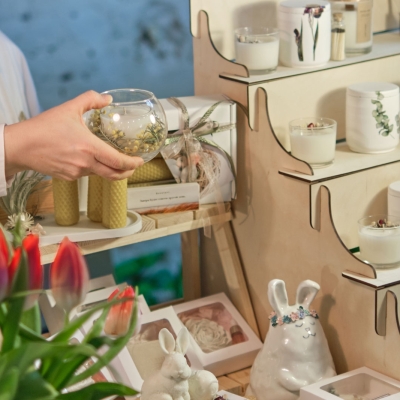 Frau hält im Geschäft eine kleiner Runde Vase in der Hand